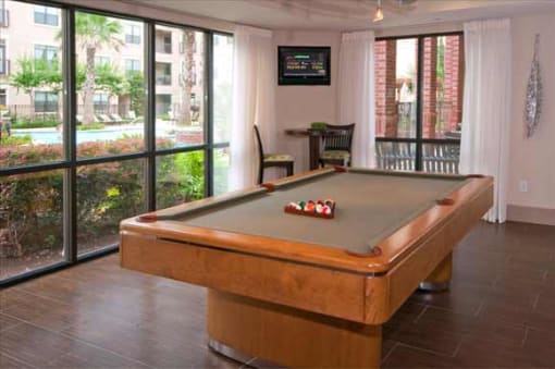 a pool table in a living room with sliding glass doors