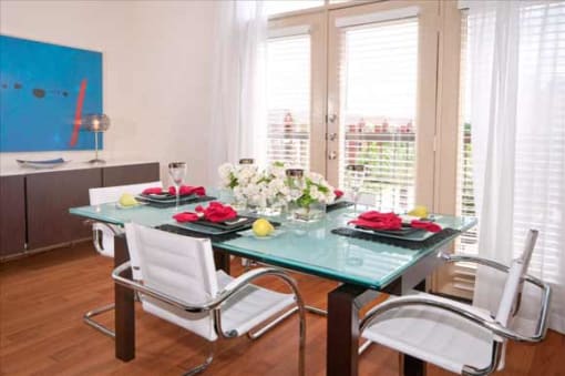 a room with a glass table and chairs in it