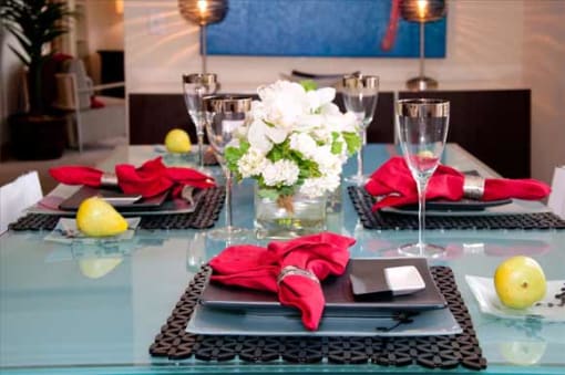 a table with plates and wine glasses and flowers on it