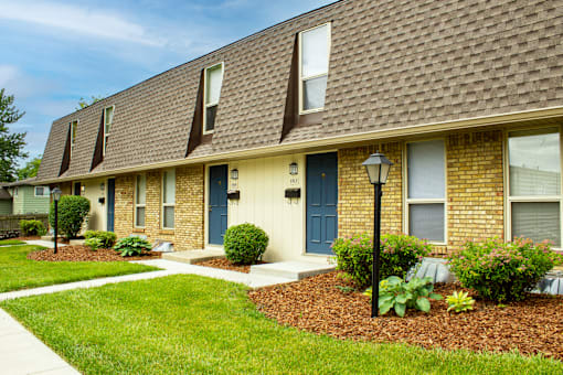A brown house with a blue door and windows.