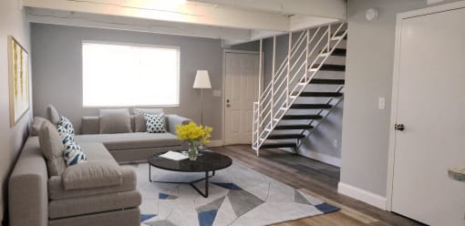 a living room with a couch and a staircase
