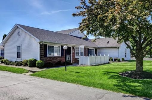 a white house with a yard and a tree