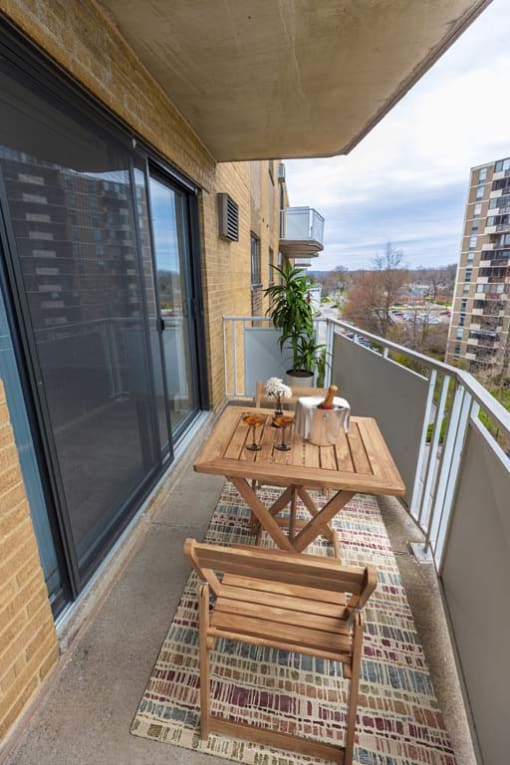 a wooden table and chairs on a balcony