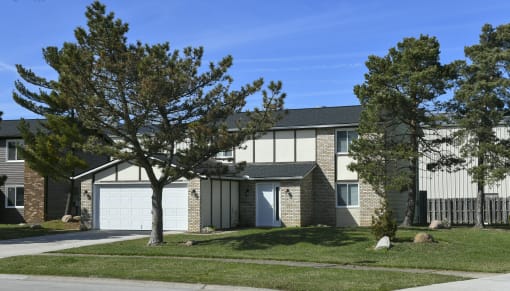a house with a lawn and trees in front of it