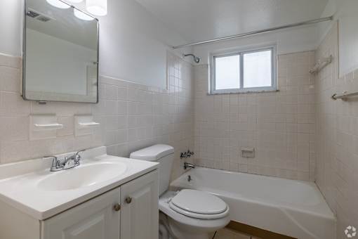 A white bathroom with a sink, toilet, and bathtub.