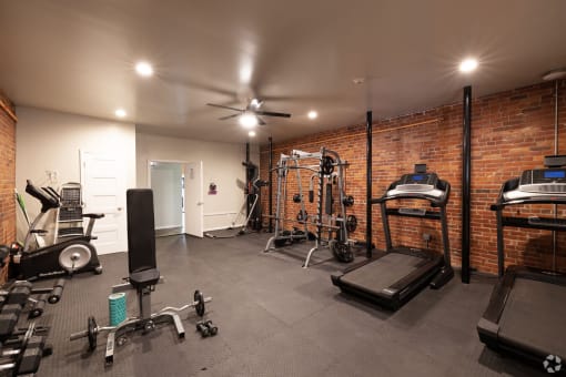 a home gym with a brick wall and exercise equipment