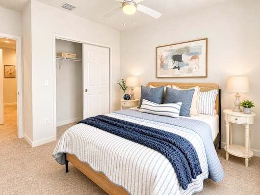 A bedroom with a bed, nightstand, and lamp.