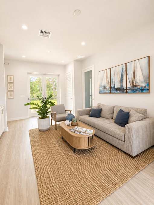 A living room with a couch, a chair, a coffee table, and a painting on the wall.
