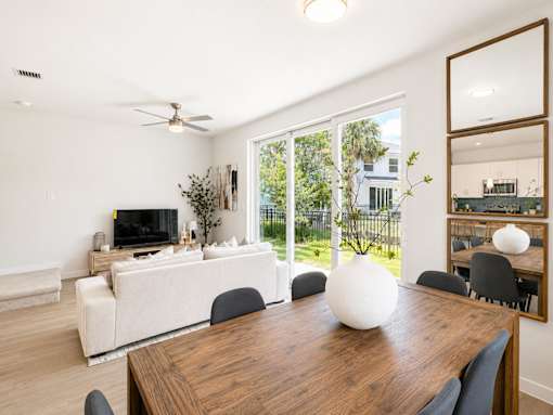 A modern dining room with a wooden table and chairs.