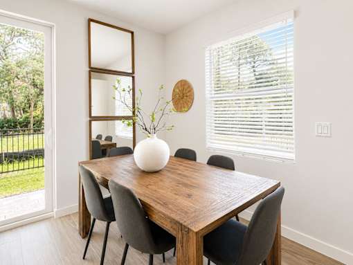 A dining room with a wooden table and chairs.