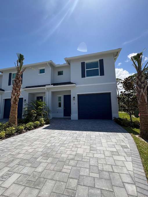 A modern two-story house with a driveway in front.