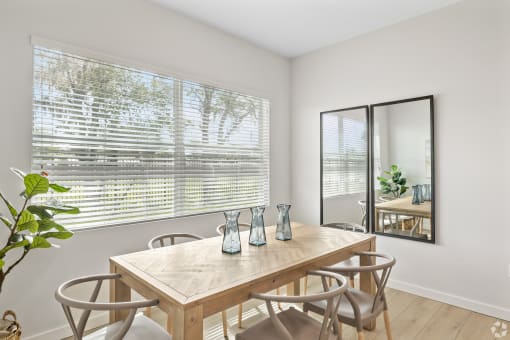 a dining room with a table and chairs and a large window