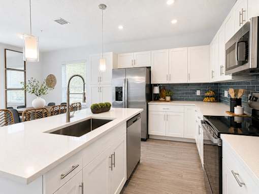 A modern kitchen with white cabinets and a black countertop.