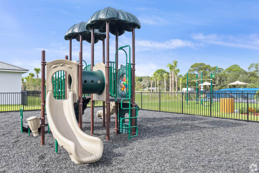 a playground with a slide and climbing equipment in a park