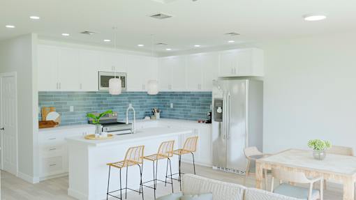 A kitchen with a blue backsplash and white cabinets.