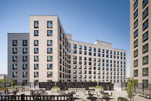 A large building with a lot of windows and a fence surrounding it.