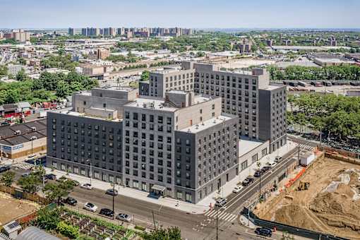 A large grey building with many windows is under construction.