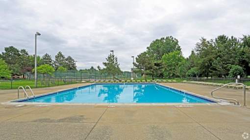 a swimming pool with trees and a fence around it