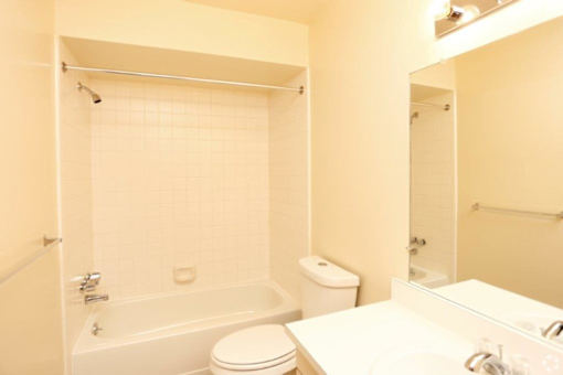 a bathroom with a toilet and a tub and a sink