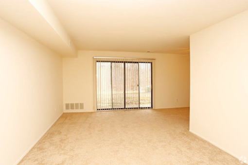 an empty living room with a sliding glass door