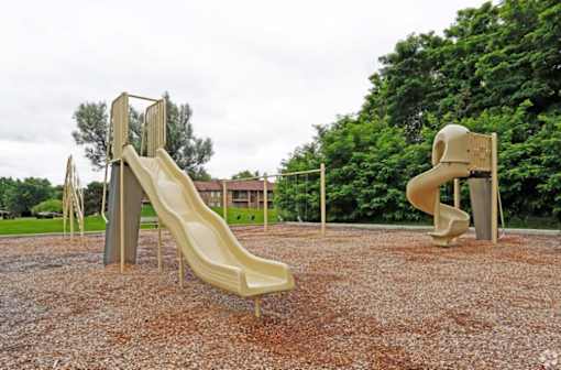 two slides on a playground in a park