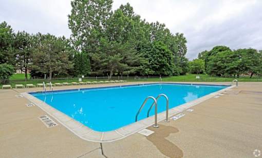 a swimming pool with trees in the background