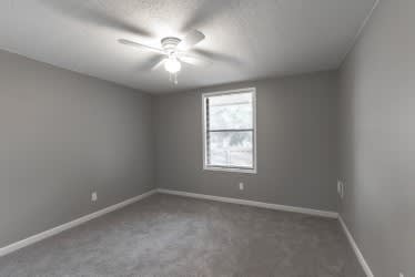 A room with a ceiling fan and a window.