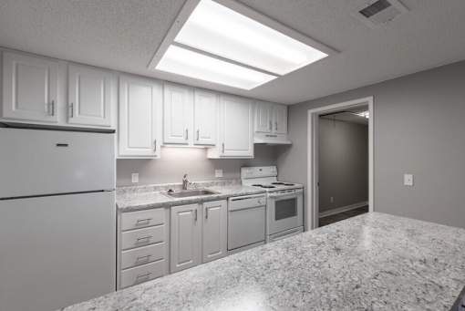 A kitchen with white cabinets and granite countertops.