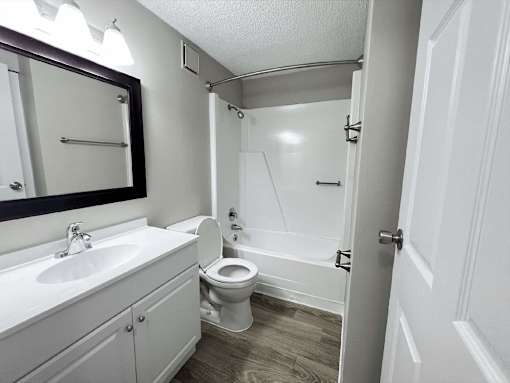 A white bathroom with a toilet, sink, and shower