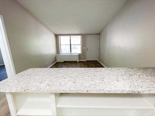 A room with a marble countertop and a window