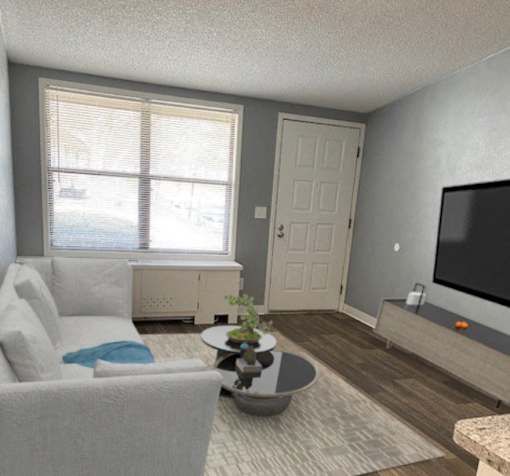 A living room with a white couch and a grey armchair
