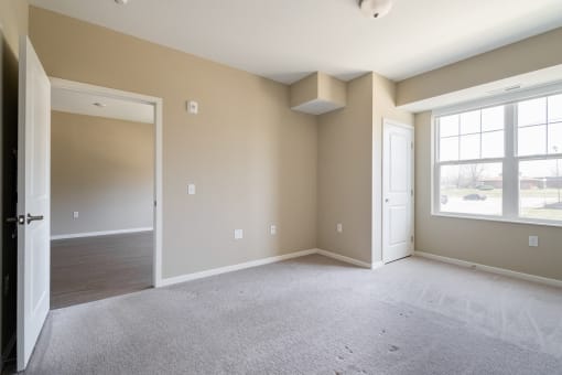 an empty bedroom with a large window