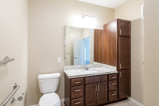 a bathroom with dark wood cabinets and a white toilet