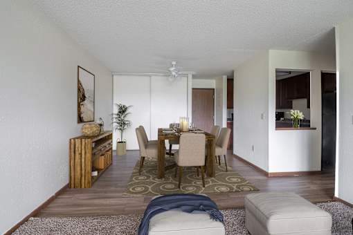 a dining room and living room with white walls and wood floors at Pheasant Park Apartments, New Hope