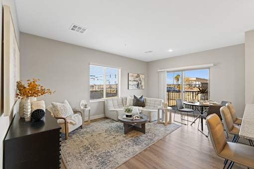 a living room with couches and chairs and a table and a balcony at Agave House Apartments, Casa Grande, 85122