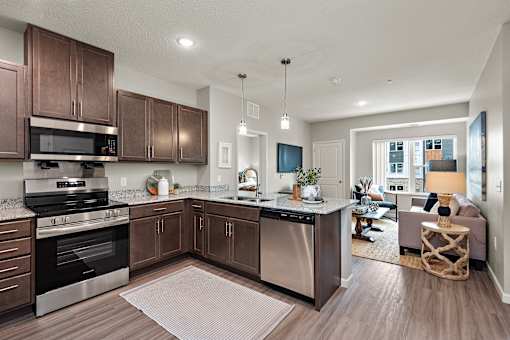 A modern kitchen with dark wood cabinets and stainless steel appliances.at Decatur Landing I & II, Minnesota, 55445