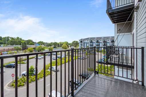 a balcony with a view of a parking lot and a building at EastGate Apartments, Rochester