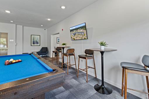 a games room with a pool table and bar with stools at EastGate Apartments, Minnesota, 55904