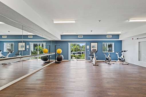 the gym with exercise equipment and mirrors at the belgard apartments at EastGate Apartments, Rochester, MN