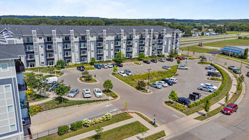 an aerial view of an apartment complex with parking lot and cars at EastGate Apartments, Rochester