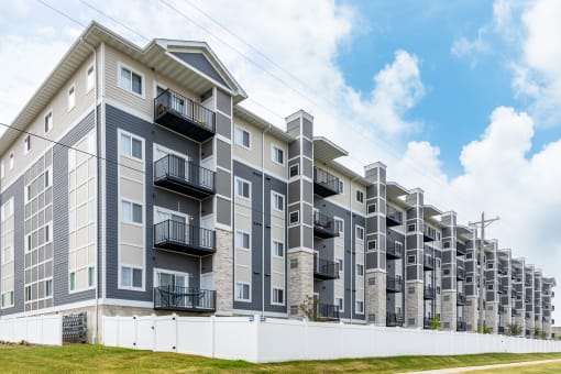 a large apartment building with balconies and a blue sky in the background at EastGate Apartments, Rochester, MN, 55904