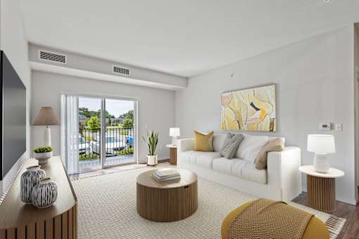 A living room with a white couch, a brown coffee table, and a large painting on the wall at EastGate Apartments, Minnesota, 55904