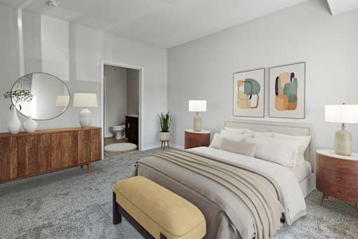 A bedroom with a large bed, a bench, and a mirror at EastGate Apartments, Rochester