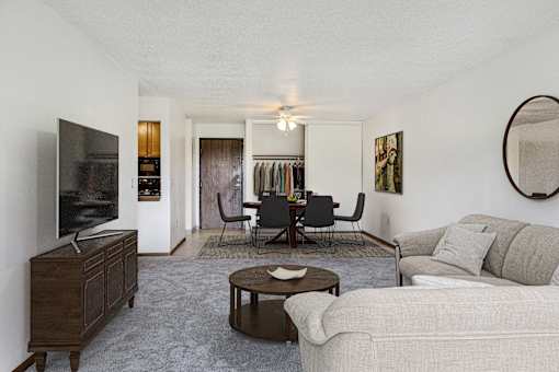 a living room with a couch and a table and a television at Pheasant Park Apartments, New Hope, MN, 55428-5401