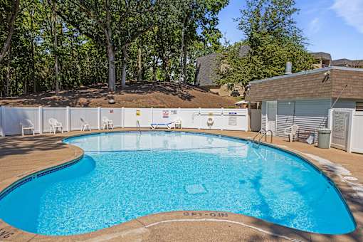 our resort style swimming pool is in front of our house with trees at Heritage Hills Apartments, Bloomington Minnesota