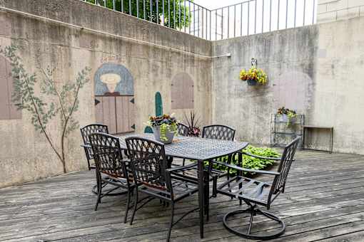 a patio with a table and chairs against a wall at Humboldt Senior 55+ Apartments, Saint Paul, MN
