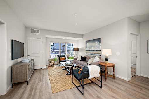 A living room with a couch, chair, and television at The Landing at Amber Fields Apartments, Rosemount, MN, 55068