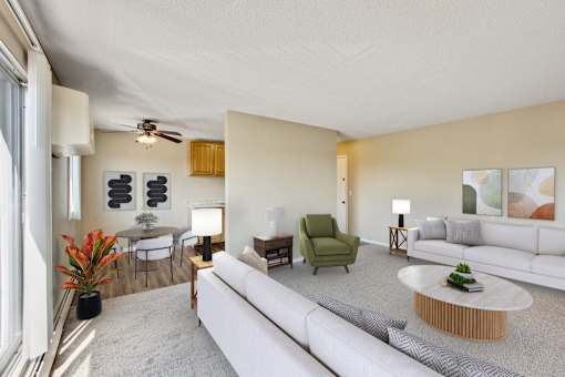 A living room with a white couch, a green chair, and a wooden coffee table at Northtown Village Apartments, Spring Lake Park