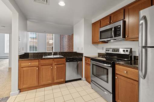 A kitchen with a black granite countertop and stainless steel appliances. at Parkside Apartments, St. Paul