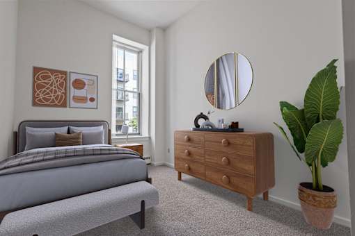 A bedroom with a bed, dresser, and mirror. at Parkside Apartments, St. Paul